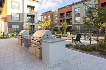A modern outdoor kitchen with a grill and sink.